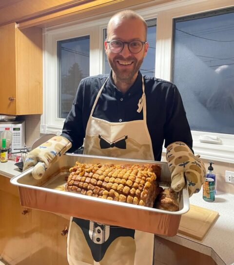 Holding a norwegian ribbe pork belly in a kitchen