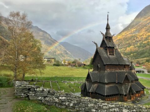A Stave Church with a rainbow behind in Norway